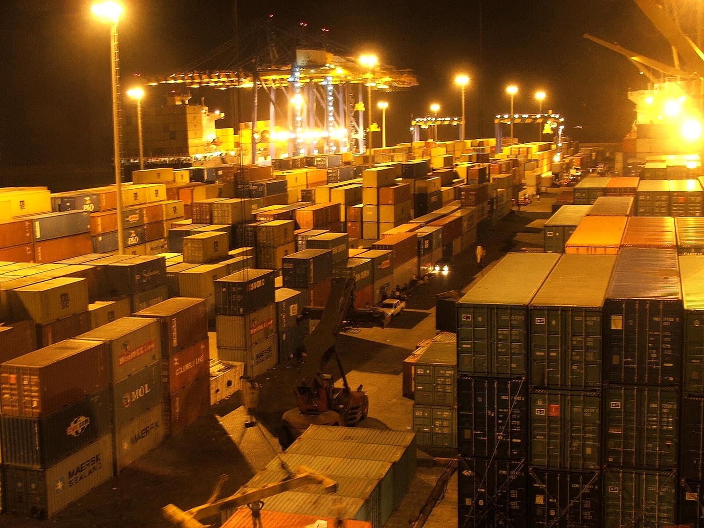 Container handling at night under floodlights at the Port of Tema, Ghana